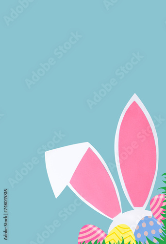 Easter background with rabbit ears and eggs on a blue background. Easter concept. Copy space.