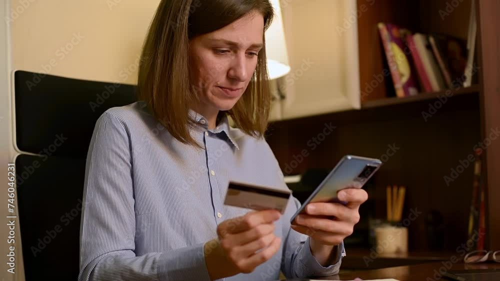Caucasian woman at table, uses smartphone to enter credit card data, buy something on internet. Female holds her cell phone, makes an easy purchase with an instant payment and secure e-bank system. Caucasian woman at table, uses smartphone to enter credit card data, buy something on internet. Female holds her cell phone, makes an easy purchase with an instant payment and secure e-bank system.