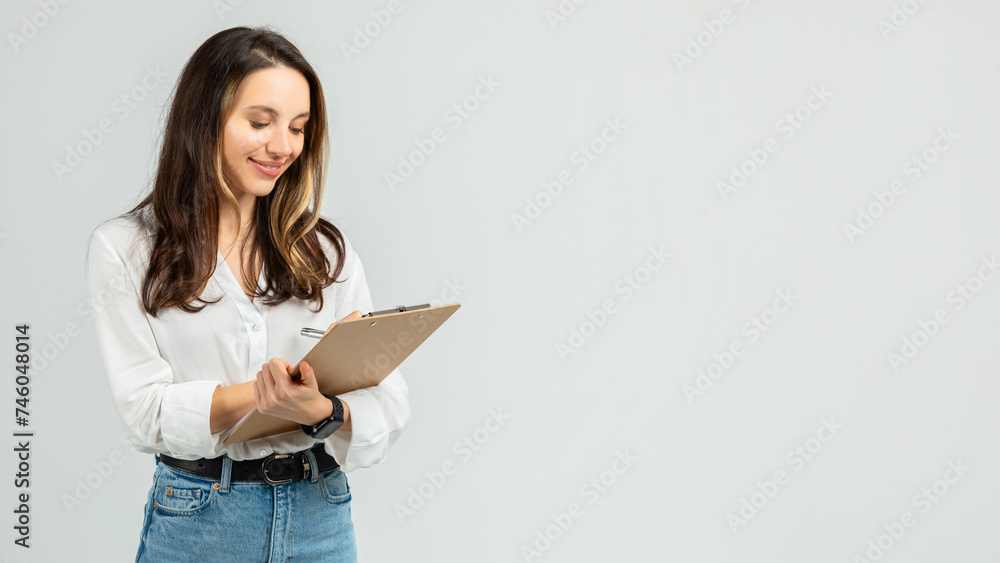 Focused young woman with a pleasant smile, wearing a crisp white blouse and blue jeans Focused young woman with a pleasant smile, wearing a crisp white blouse and blue jeans
