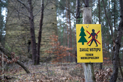 Ogrodzenie i tabliczka ostrzegająca o wejściu na niebezpieczny teren w lesie