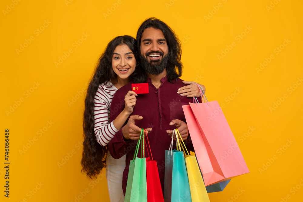 Loving young indian couple enjoying easy shopping together Loving young indian couple enjoying easy shopping together