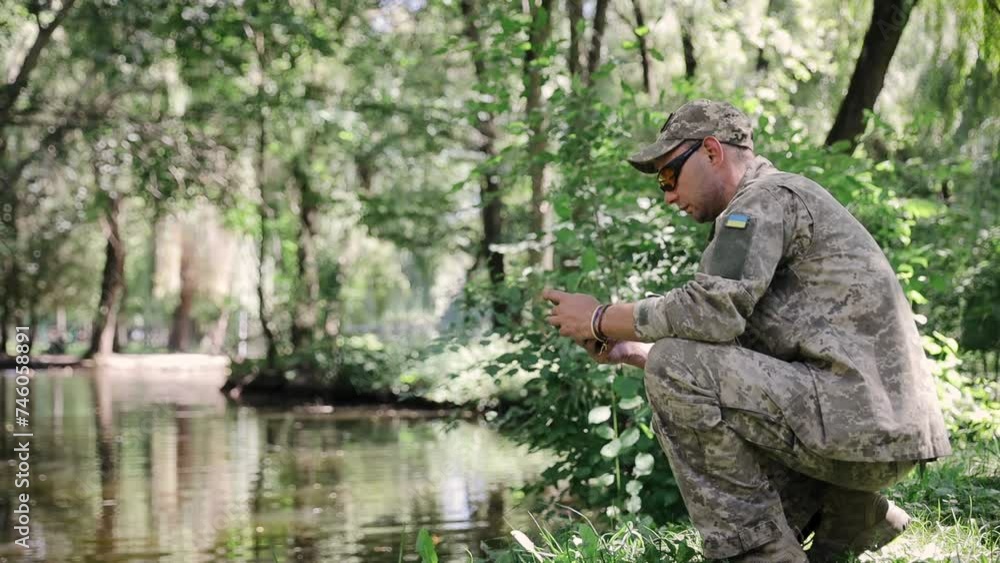 Army military soldier checking mobile phone in forest wearing camouflage uniform and tactical googles. Ukrainian Armed Forces