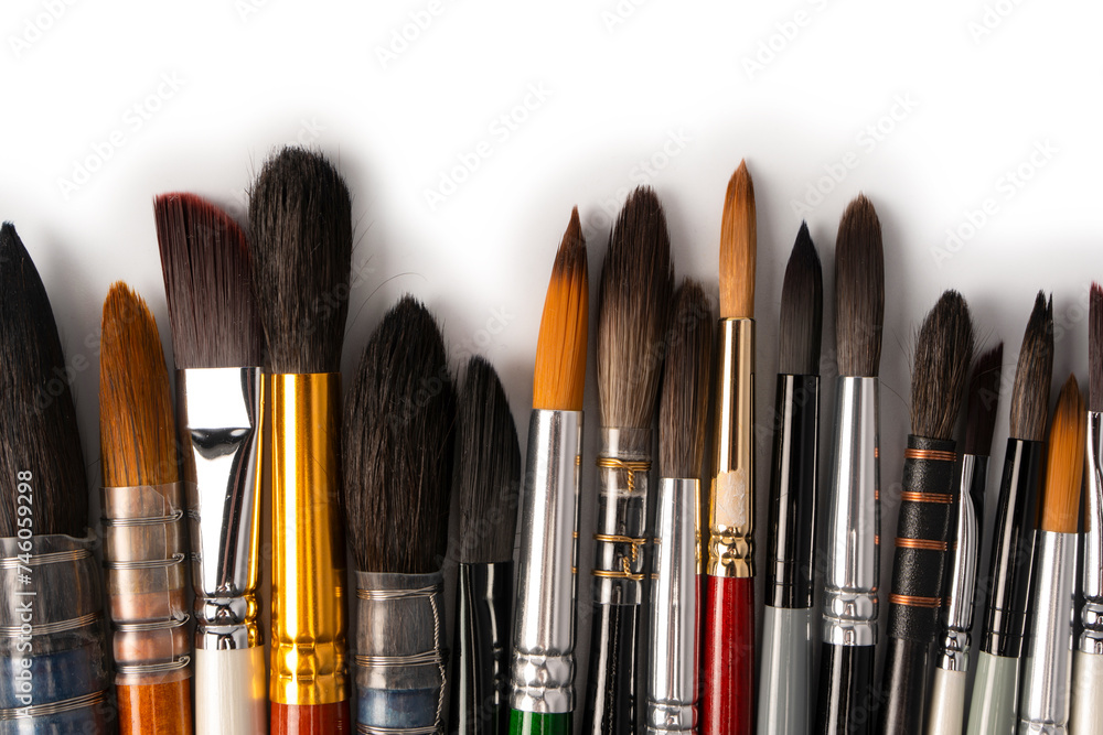 Mix of paint brushes in a row isolated on a white background. Mix of paint brushes in a row isolated on a white background.