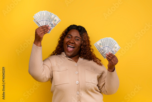 Lucky happy african american overweight woman with cash photo