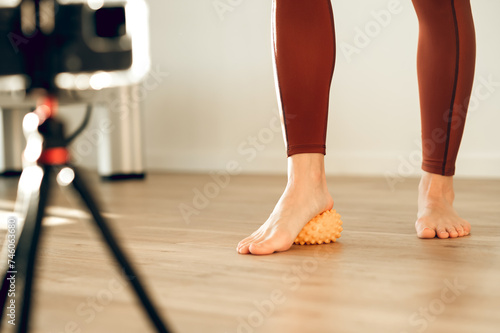 Online stream coach showing technique exercise self massage ball relaxation of muscles of feet