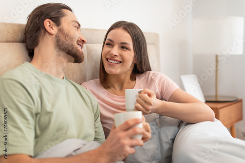 Happy couple enjoying coffee in bed, relaxed morning