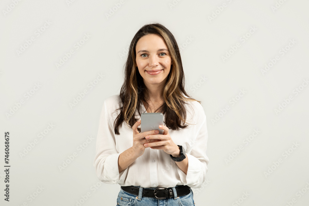 Content woman looking at her smartphone, potentially reading a message Content woman looking at her smartphone, potentially reading a message