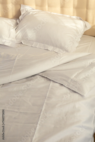 crumpled white bed linen morning routine in sunlight