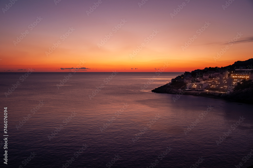 Sunset in Dubrovnik with a view of the buildings, calm sea during sunset, sunset colors