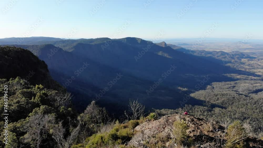 aerial view of hiker girl enjoying the panorama of scenic mountains in main range national park, south east queensland, australia; sunset over bare rock, mount cordeaux, mount mitchell aerial view of hiker girl enjoying the panorama of scenic mountains in main range national park, south east queensland, australia; sunset over bare rock, mount cordeaux, mount mitchell