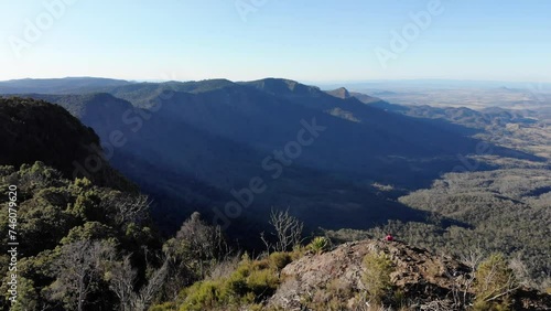 aerial view of hiker girl enjoying the panorama of scenic mountains in main range national park, south east queensland, australia; sunset over bare rock, mount cordeaux, mount mitchell photo