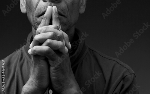 black man praying to god with hands together Caribbean man praying on black background with people stock photos stock photo © herlanzer
