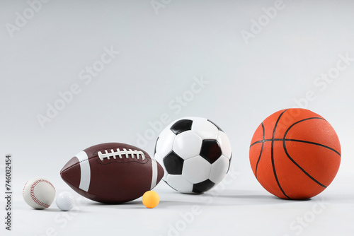 Many different sports balls on light gray background, space for text
