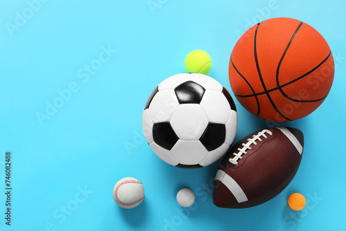Many different sports balls on light blue background  flat lay. Space for text
