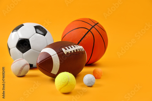 Many different sports balls on yellow background, space for text © New Africa