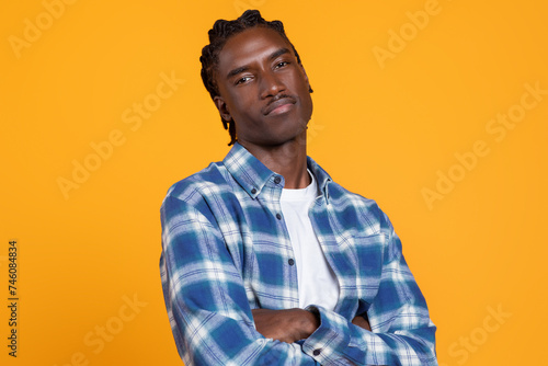 Confident Young African American Man Standing With Folded Arms On Yellow Background