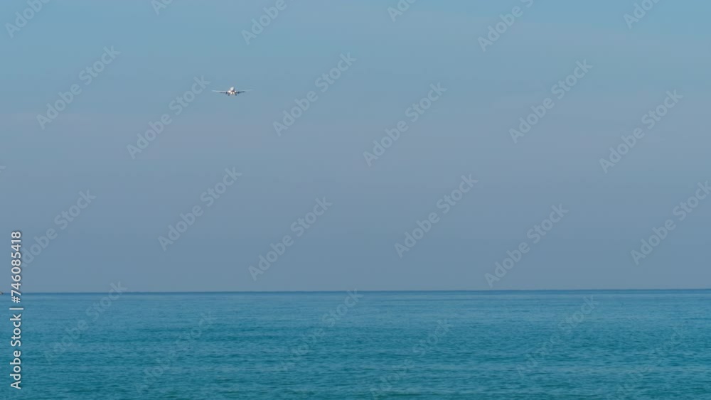 Airplane approaching to landing. Airliner flies over the blue sea. Plane in the sky Airplane approaching to landing. Airliner flies over the blue sea. Plane in the sky