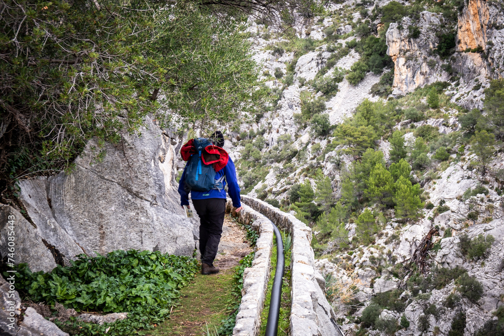 hiker in a small channel on the Torrent d'Aumadrà, Tossals Verds, Escorca, Mallorca, Balearic Islands, Spain