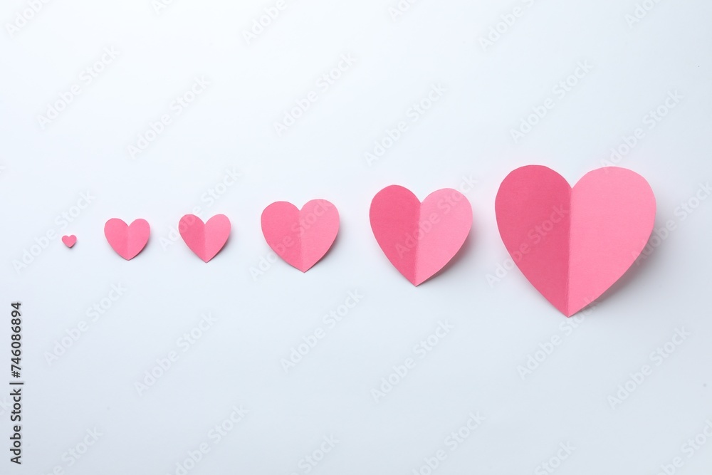 Pink paper hearts on white background, flat lay