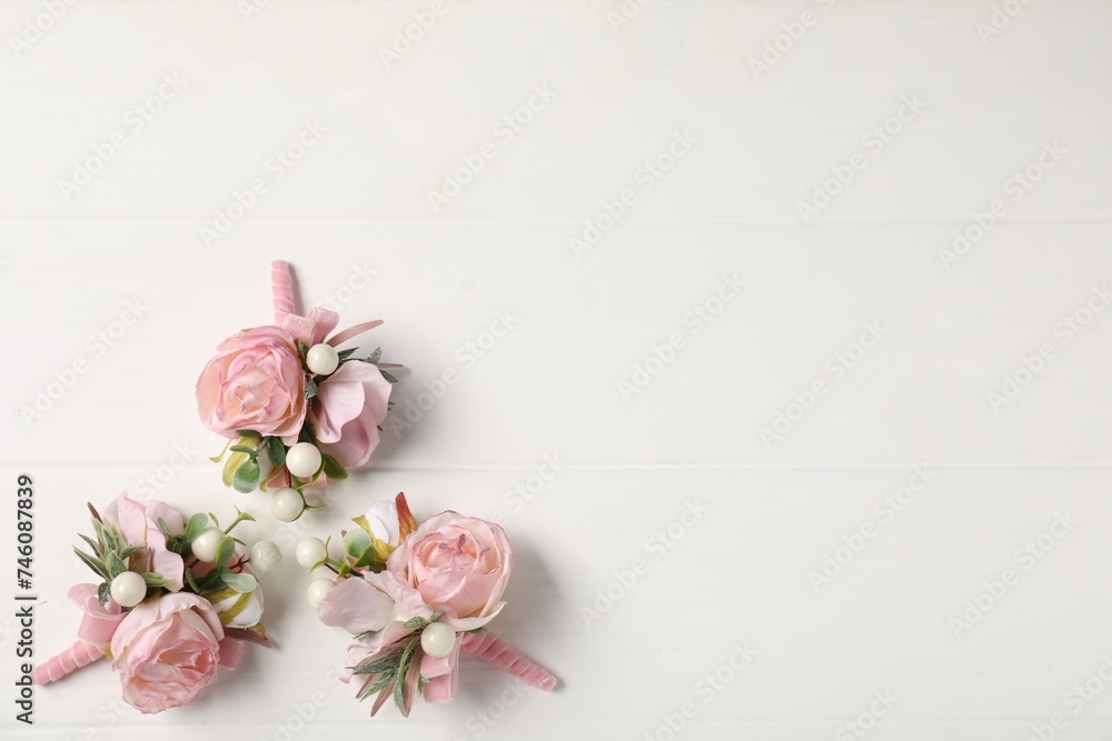 Beautiful boutonnieres on white background, flat lay. Space for text - obrazy, fototapety, plakaty 