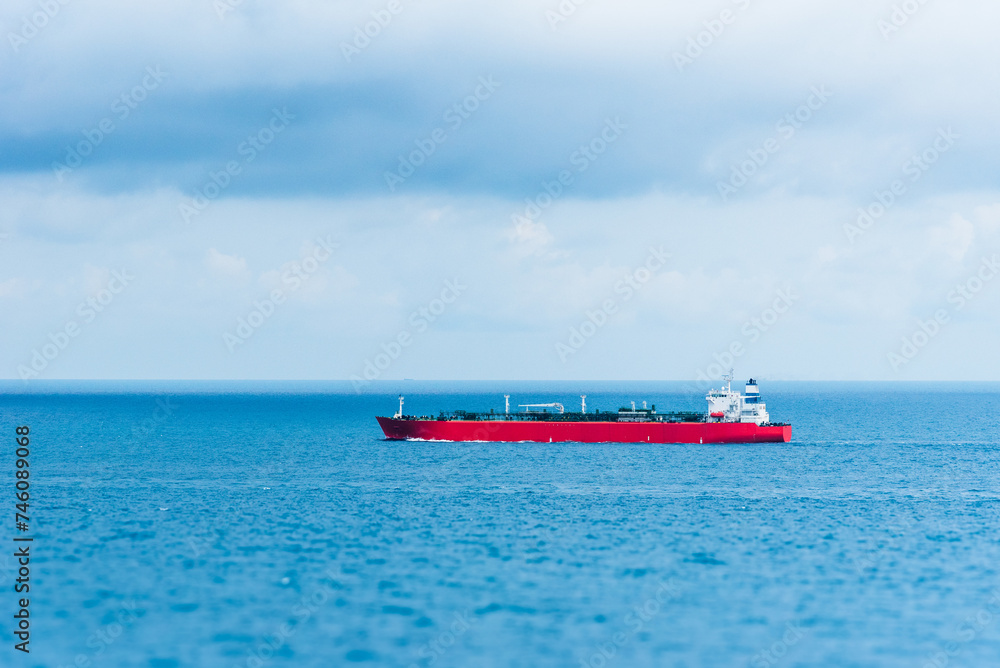 Tanker ship, sailing through calm, blue ocean. She is transporting cargo on her international trade route. 