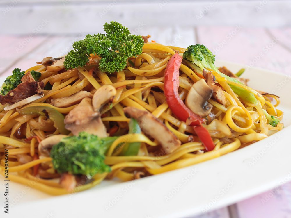 CHICKEN TERIYAKI NOODLES Include broccoli, carrot, tomato and spring onion served in dish isolated on table closeup side view of chinese food CHICKEN TERIYAKI NOODLES Include broccoli, carrot, tomato and spring onion served in dish isolated on table closeup side view of chinese food