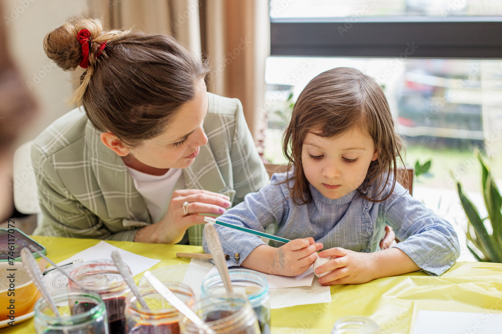 Mother Teaching Daughter Easter Egg Painting. Easter concept.