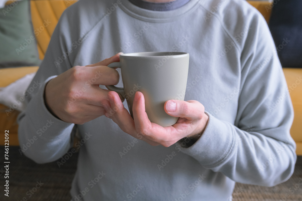man no face sitting on the floor at home, holding cup of coffee, cozy home lifestyle man no face sitting on the floor at home, holding cup of coffee, cozy home lifestyle