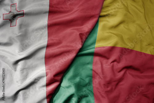 big waving national colorful flag of benin and national flag of malta.