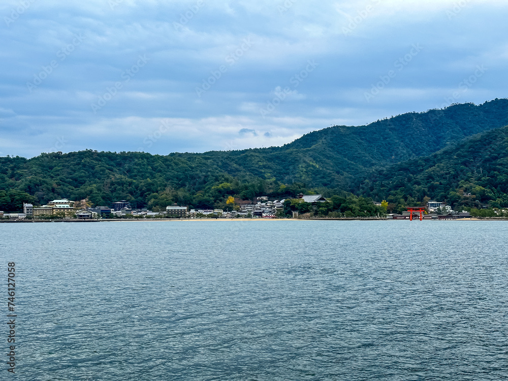 Scenery of Miyajima Island and the Hiroshima Bay Inland Sea. Miyajima can be reached by regular ferry from main island. Cloudy autumnal day. Itsukushima is part of the city of Hatsukaichi in Hiroshima Scenery of Miyajima Island and the Hiroshima Bay Inland Sea. Miyajima can be reached by regular ferry from main island. Cloudy autumnal day. Itsukushima is part of the city of Hatsukaichi in Hiroshima