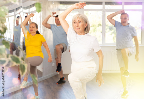 Group of aged people rehearsing sports dance in dance hall