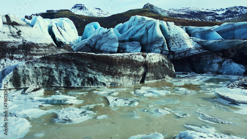 Beautiful vatnajokull glacier drone shot, massive ice blocks and icebergs with blue color. Spectacular icelandic glacier lagoon with snowy mountains and fantastic frozen rocks. Slow motion.