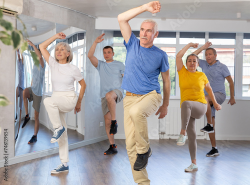 Enthusiastic elderly man attending group choreography class, learning modern dynamic dances. Concept of active lifestyle of older generation ..