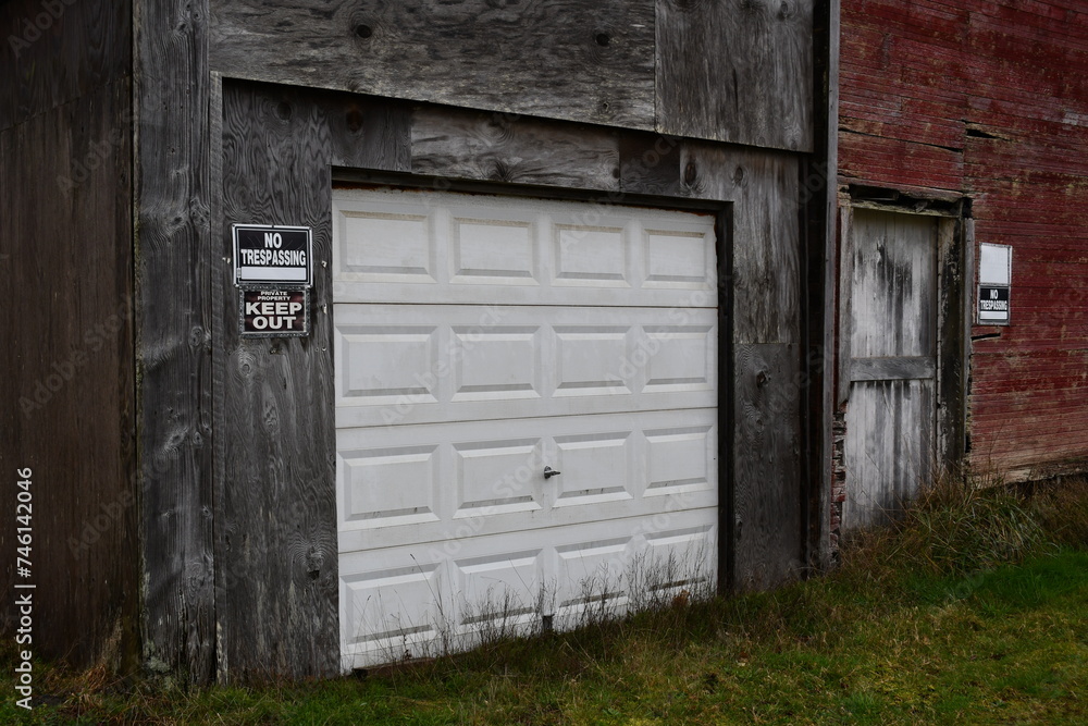 Garage door on old barn, no trespass sign.