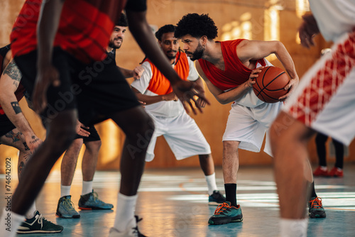 A hispanic basketball player defending ball during training with team. photo