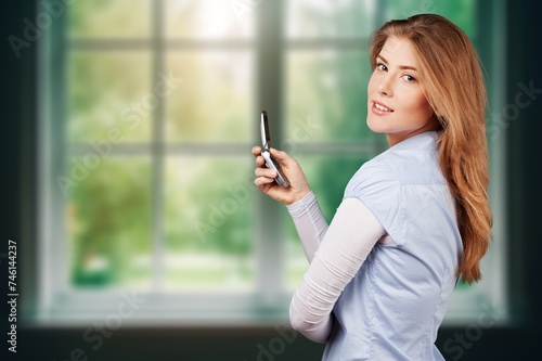 Young teen woman at home by window