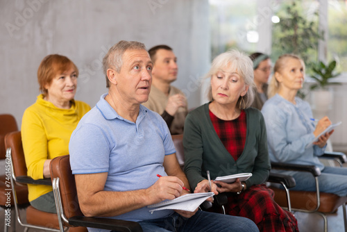 Older male and female students listening to lecture in university © JackF