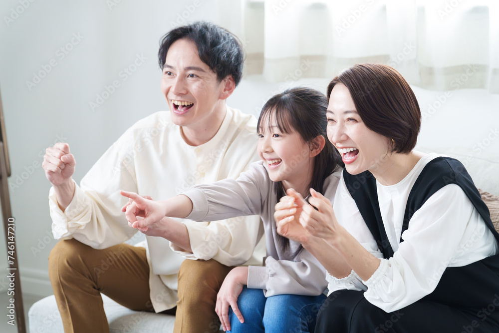 リビングで試合を観戦する親子