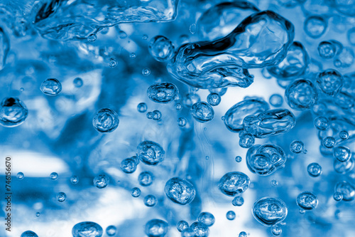 Captivating image showing the detailed beauty of water droplets in motion, highlighted with a mesmerizing blue hue for a cool, fresh vibe.