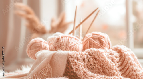 Knitting needles and yarn balls in basket with soft focus.