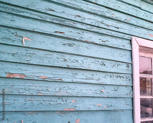 blue paint peeling from wood paneling 