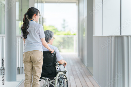 散歩する介護士・理学療法士と高齢者女性（日本人） 