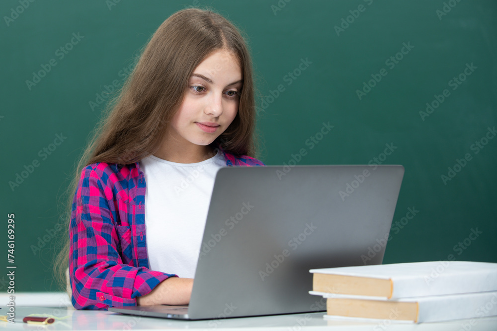 School girl with laptop at school. Teenager Student Working On Laptop in classroom. Little girl using laptop, study online on computer. Homeschooling concept. School lesson. School girl with laptop at school. Teenager Student Working On Laptop in classroom. Little girl using laptop, study online on computer. Homeschooling concept. School lesson.
