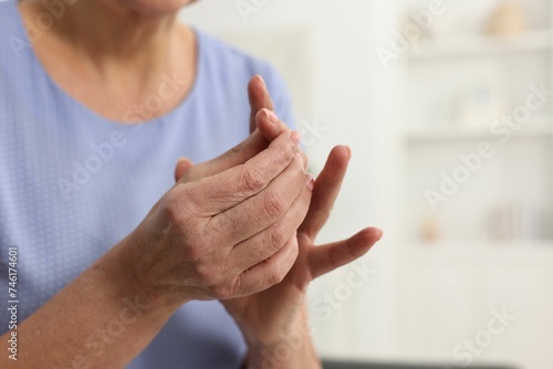 Arthritis symptoms. Woman suffering from pain in finger at home, closeup