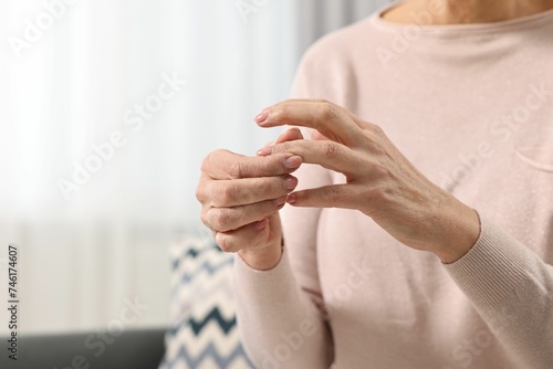Arthritis symptoms. Woman suffering from pain in finger at home, closeup. Space for text