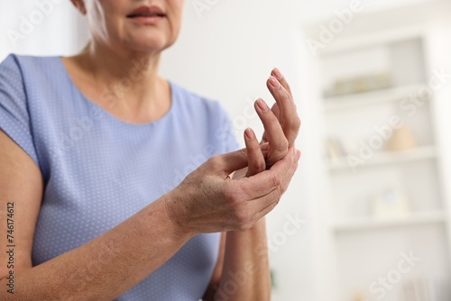 Arthritis symptoms. Woman suffering from pain in hand at home, closeup. Space for text