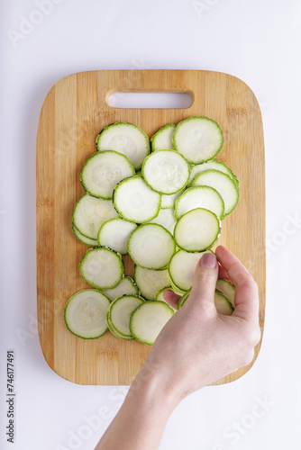 Cucumber sliced on a wooden chopping board and white background ingredient for recipe