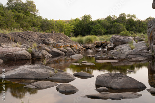 View of the river across the rocky hills at sunset. The sky reflection in the water surface. photo