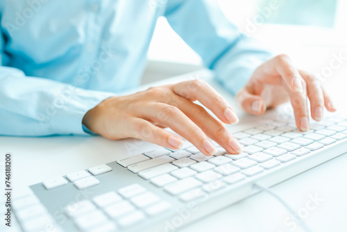 Woman office worker typing on the keyboard © biletsky