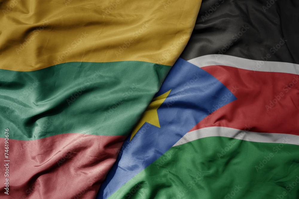 big waving national colorful flag of south sudan and national flag of lithuania .